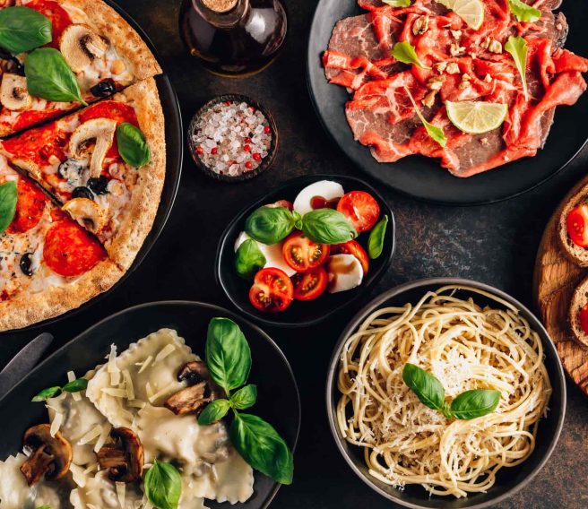 Photo of a spread of different kinds of food including pizza, pasta, ravioli etc.